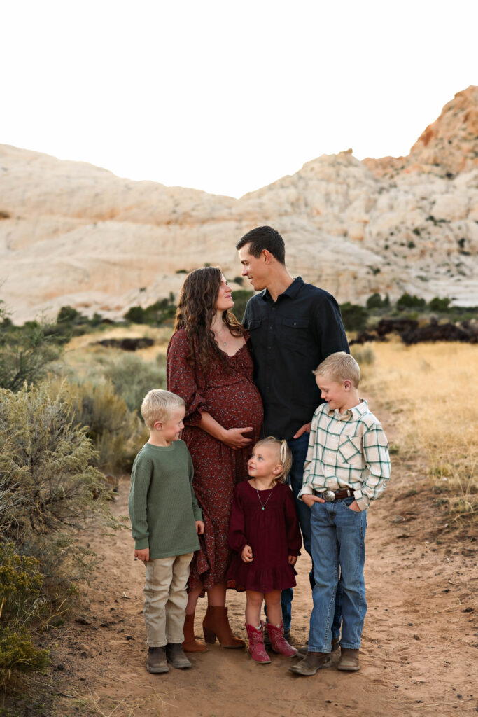 Family of five standing together for a family portrait on the White Rocks trail in Snow Canyon State Park.