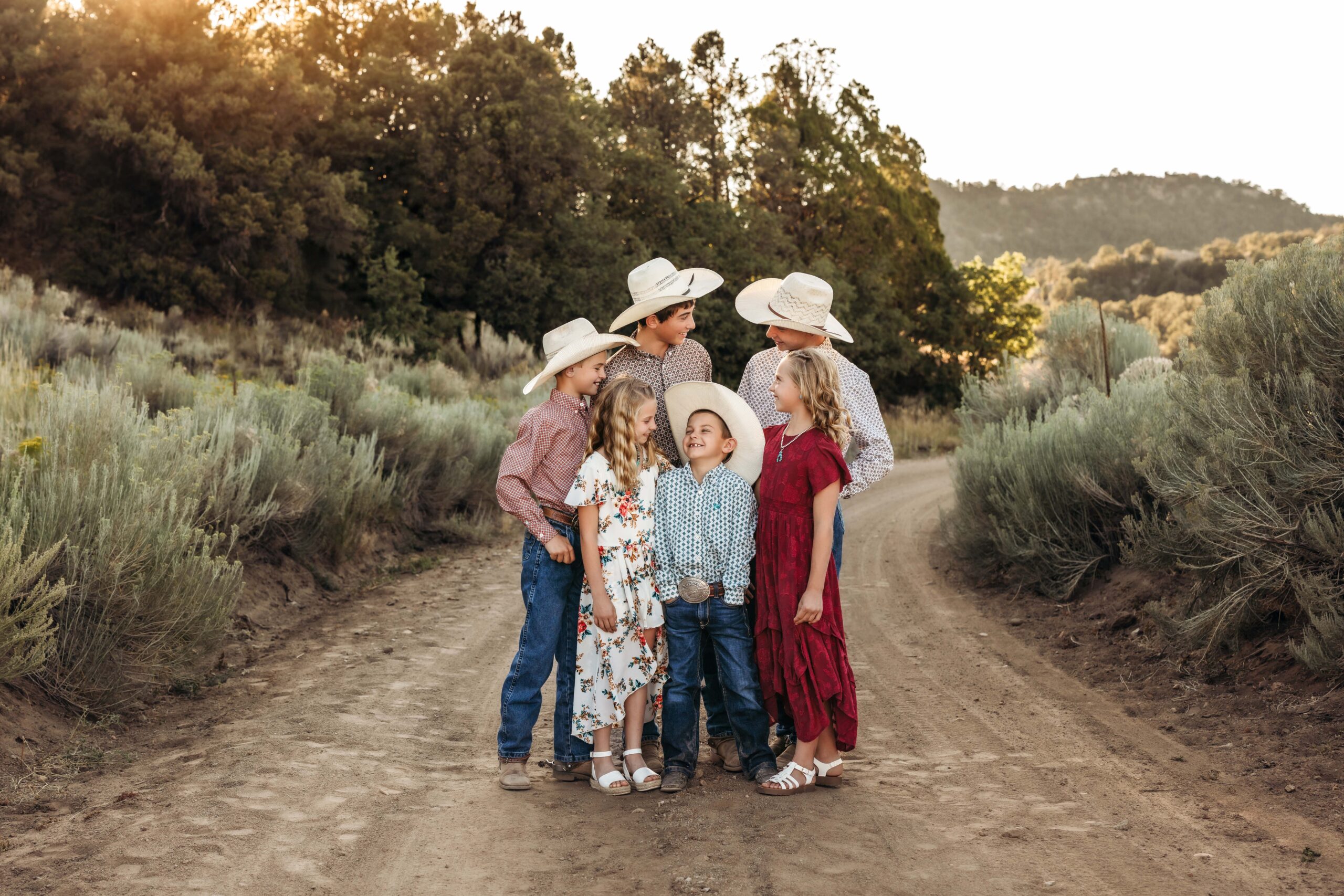 Six sibling snuggle together and make each other smile during a family photo session