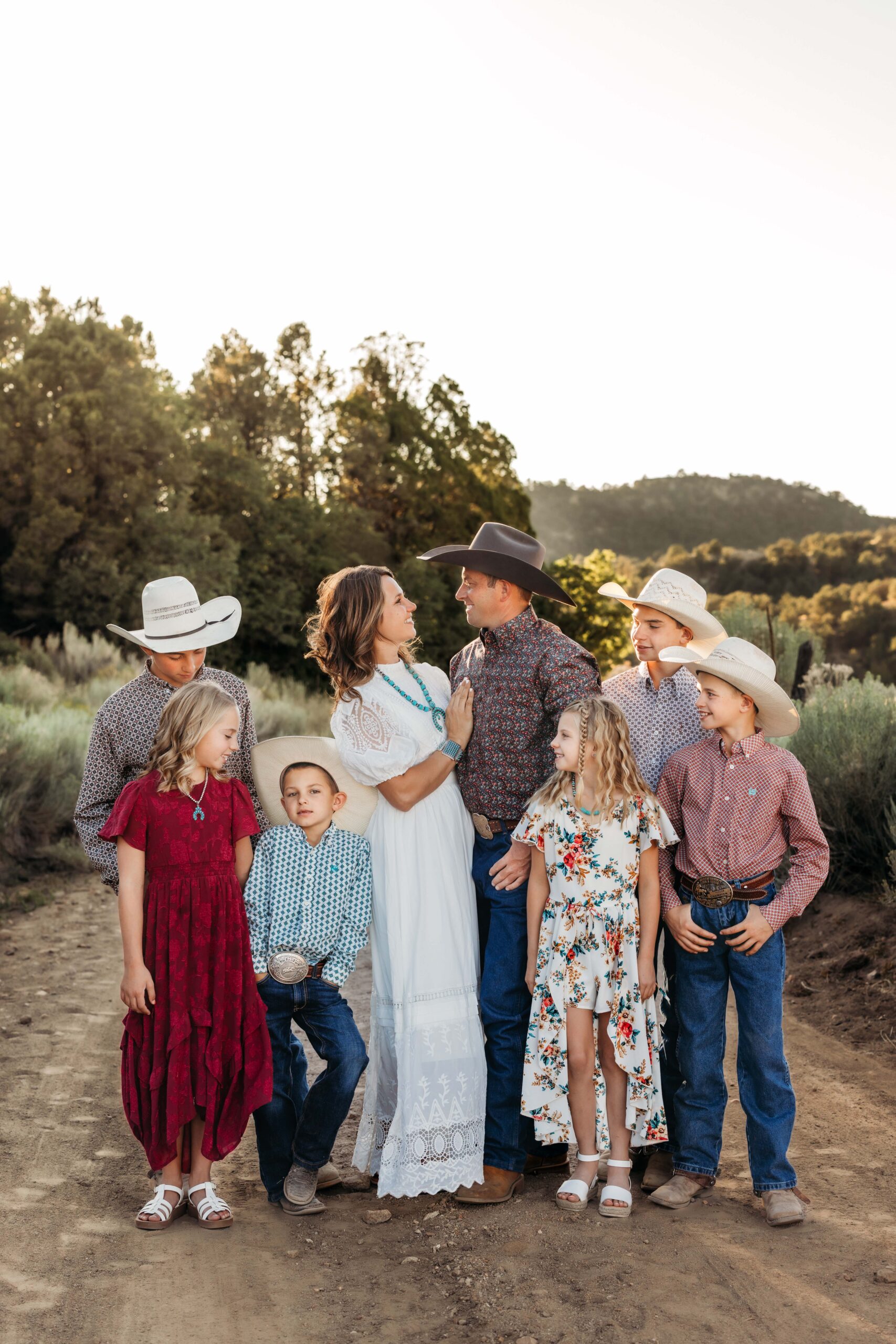 Family of eight laughing and snuggled up for a family portrait on a dirt road in southern Utah